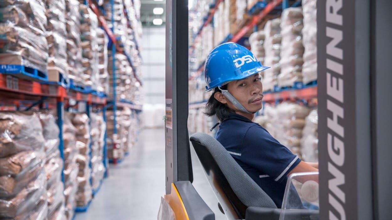 asian male warehouse worker wearing a safety helmet